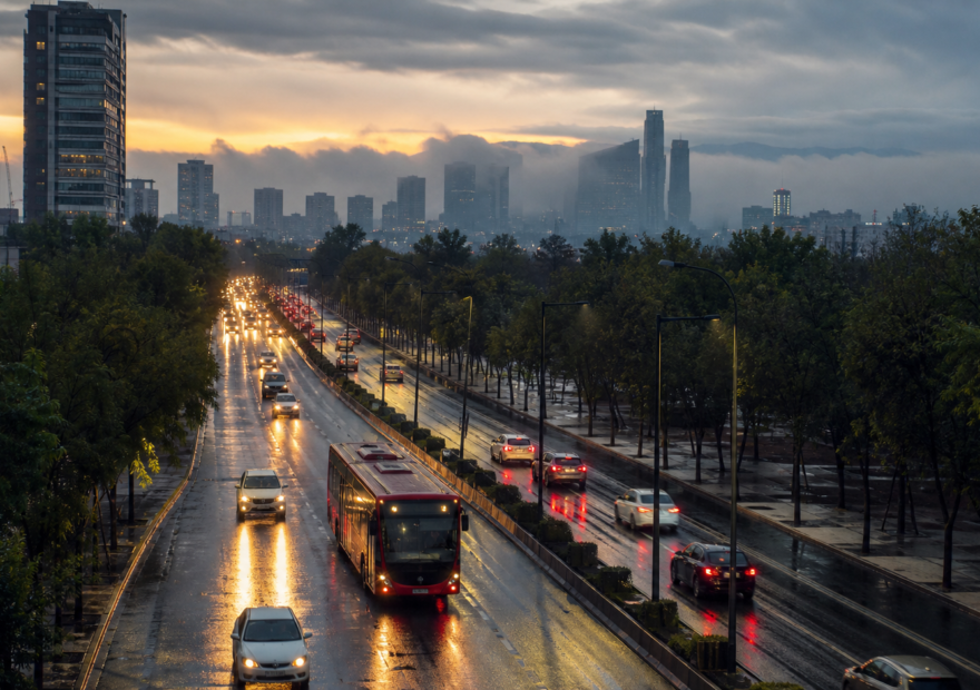Avenida de Ciudad de México con tráfico matutino y pavimento mojado bajo cielo nublado