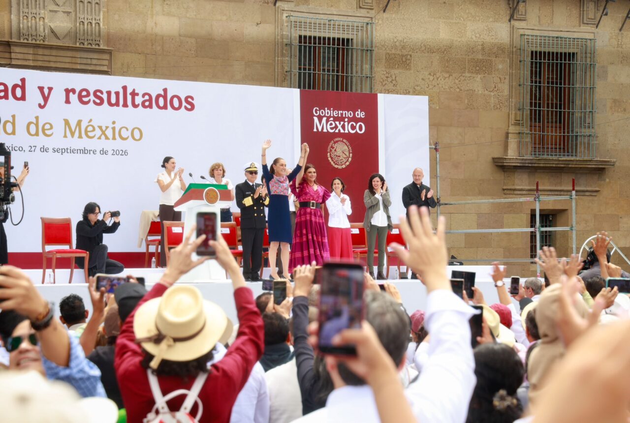 Claudia Sheinbaum saluda desde el templete, acompañada de autoridades, ante asistentes al Zócalo.